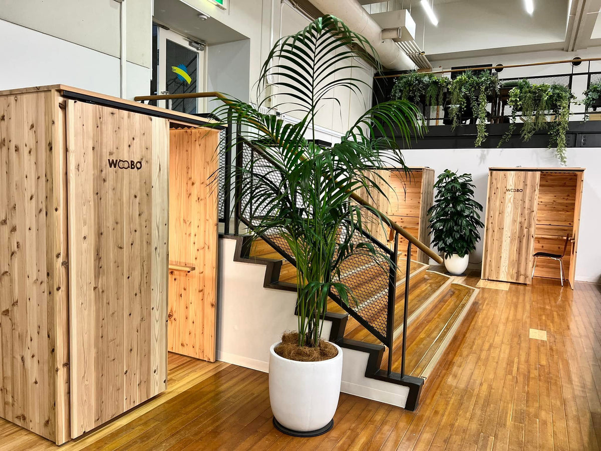 観葉植物とともに置かれた天然木ワークブースWOOBO。オンライン面談や採用面談に使われている
